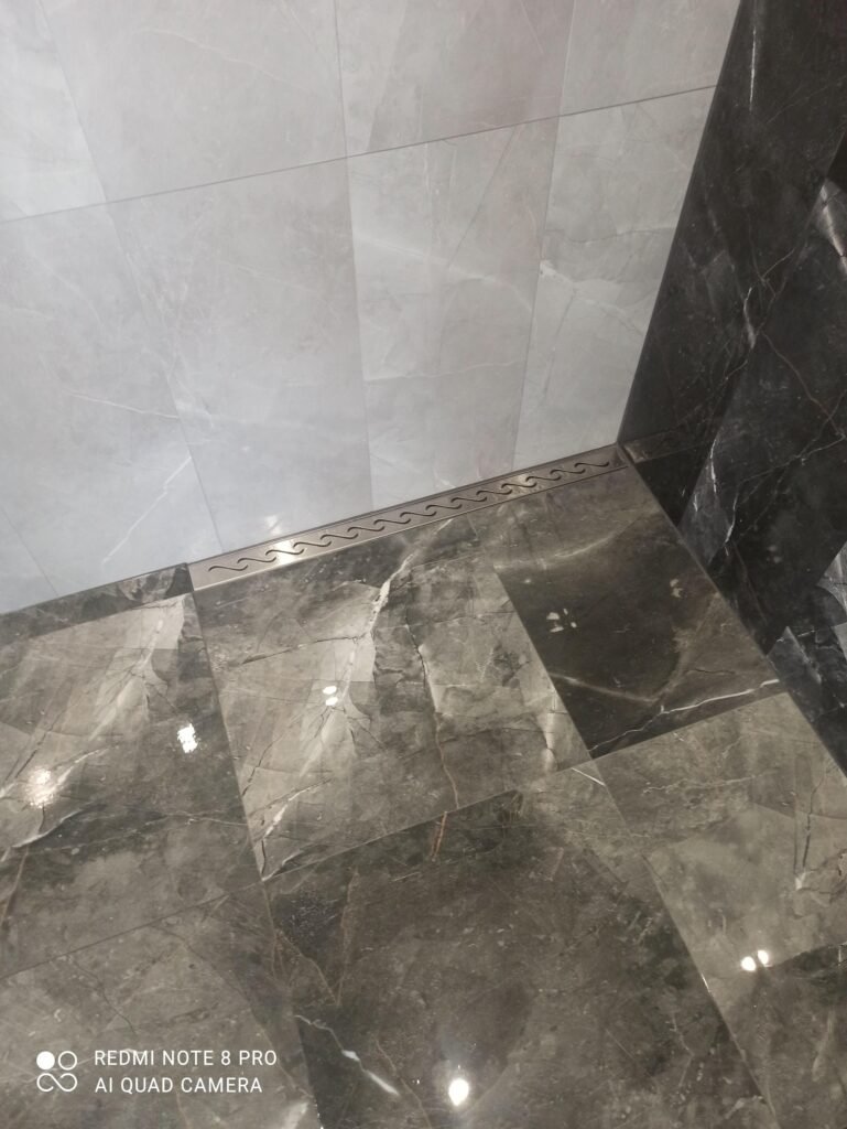 Badkamer met marmerlook tegels op vloer en wand