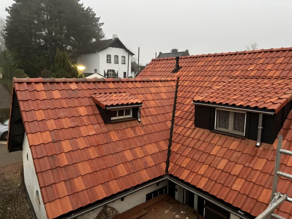 Vernieuwd dak met dakkapellen en rode dakpannen