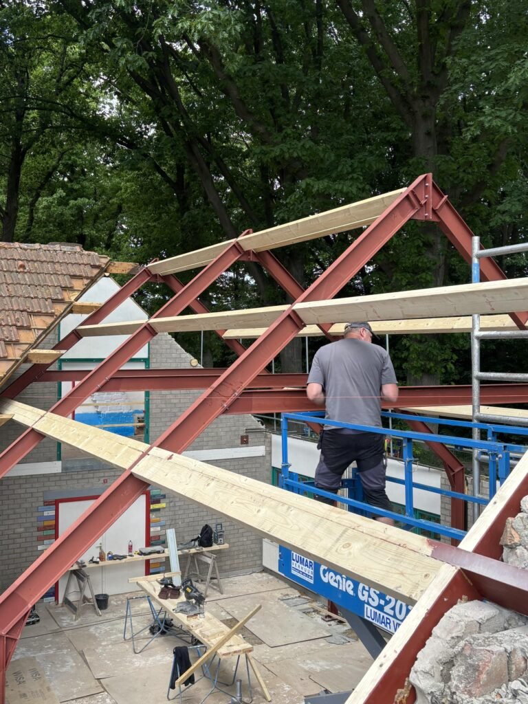 Stalen en houten kapconstructie voor een hellend dak in aanbouw Stalen en houten kapconstructie voor een hellend dak in aanbouw