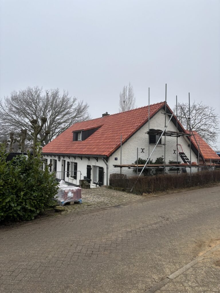 Woning met rode dakpannen tijdens de dakwerkzaamheden